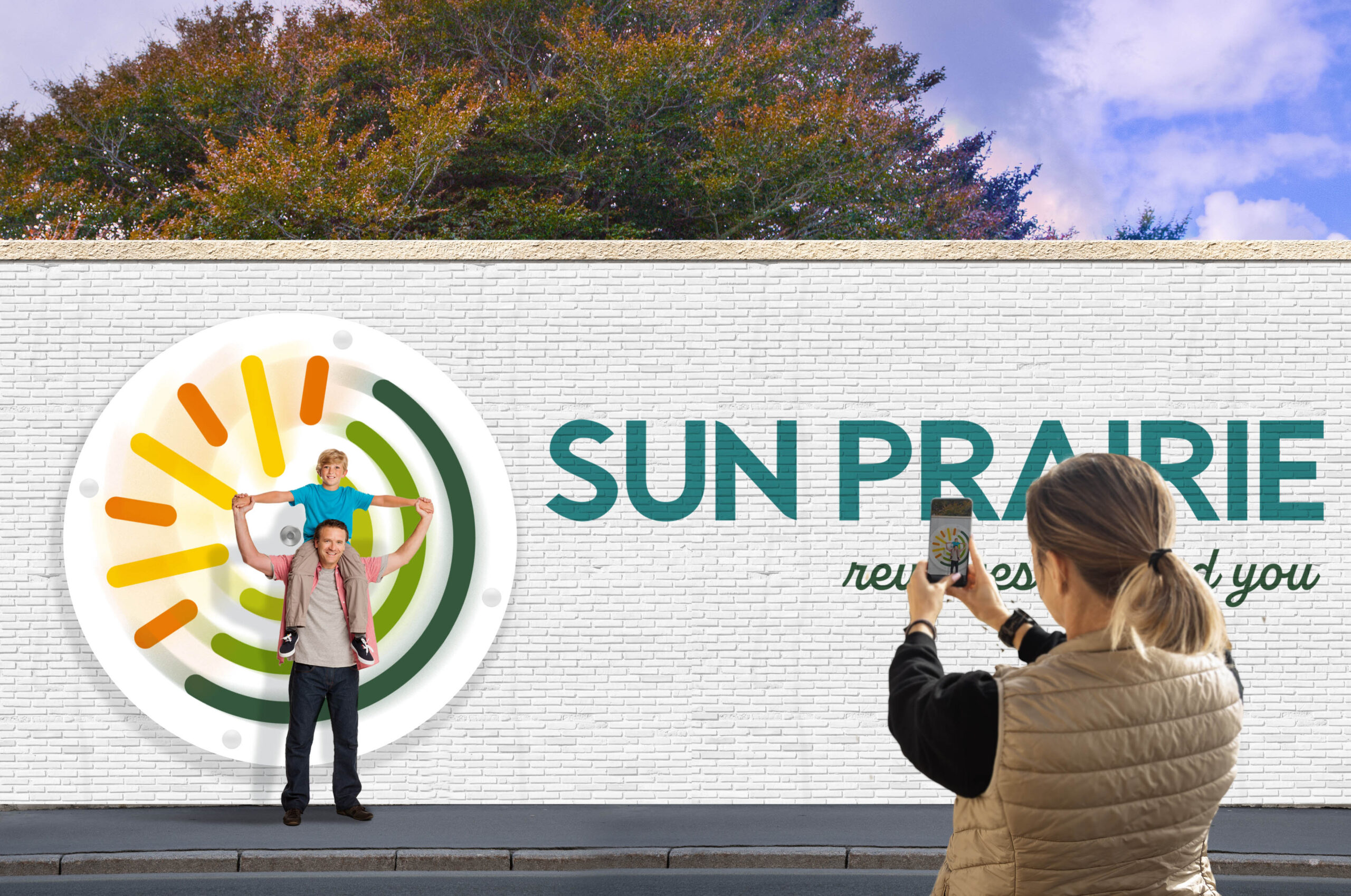 father and son pose in front of revolving Sun Prairie signage