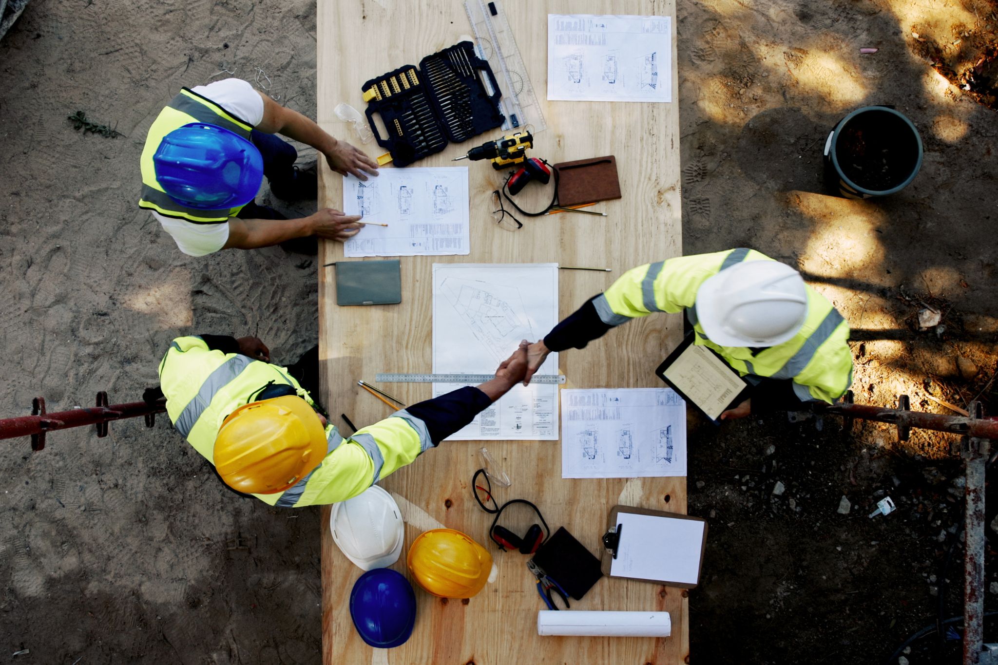 Three workers in the trades make plans for community building.